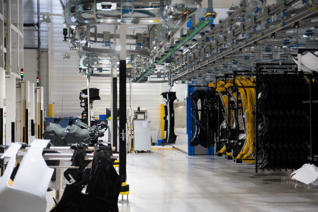 Proceso productivo en planta Tier 1 automóvil con Andon y transportador aéreo